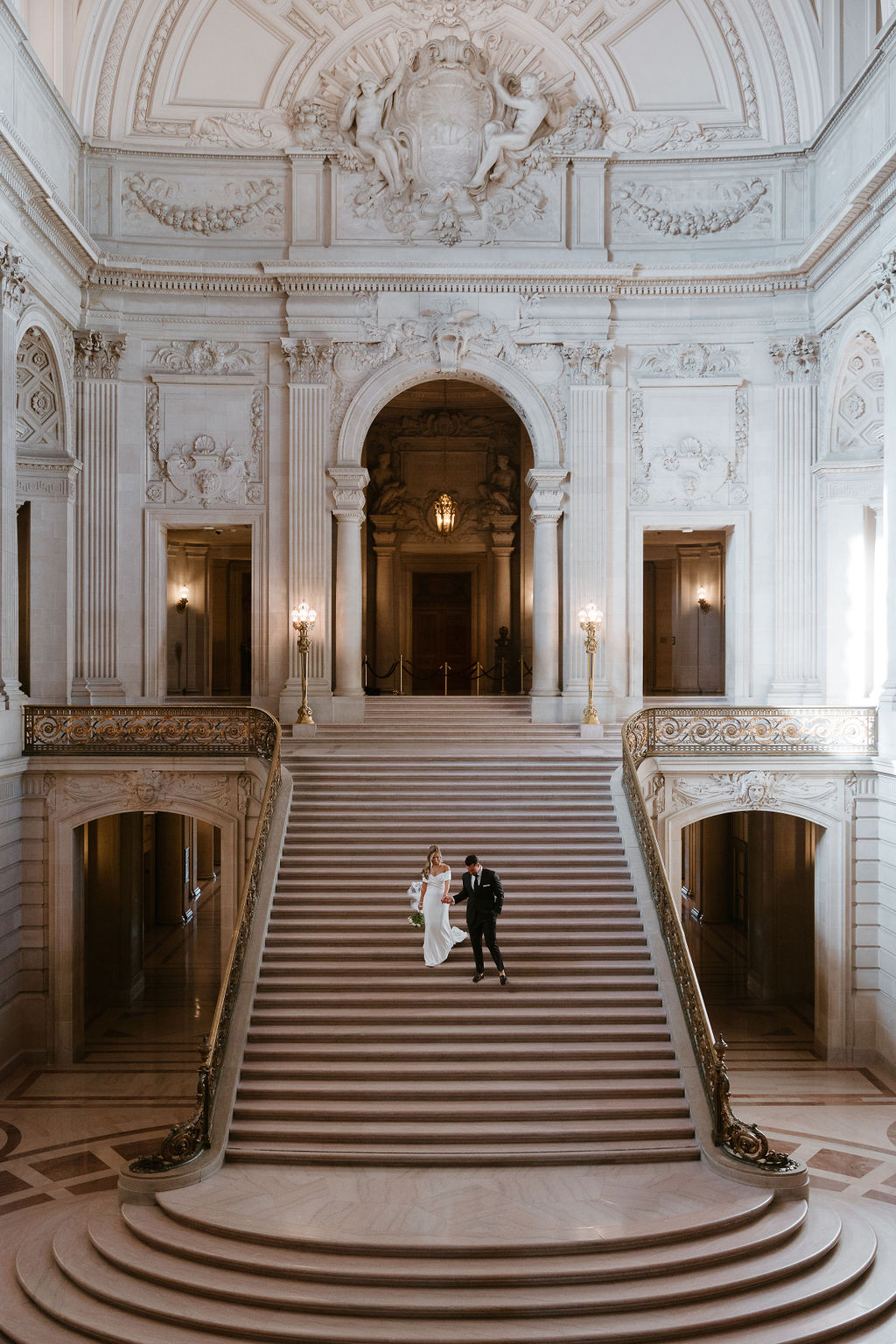 Wide angle view of the bridal portraits on the grand staircase at San Francisco City Hall in California