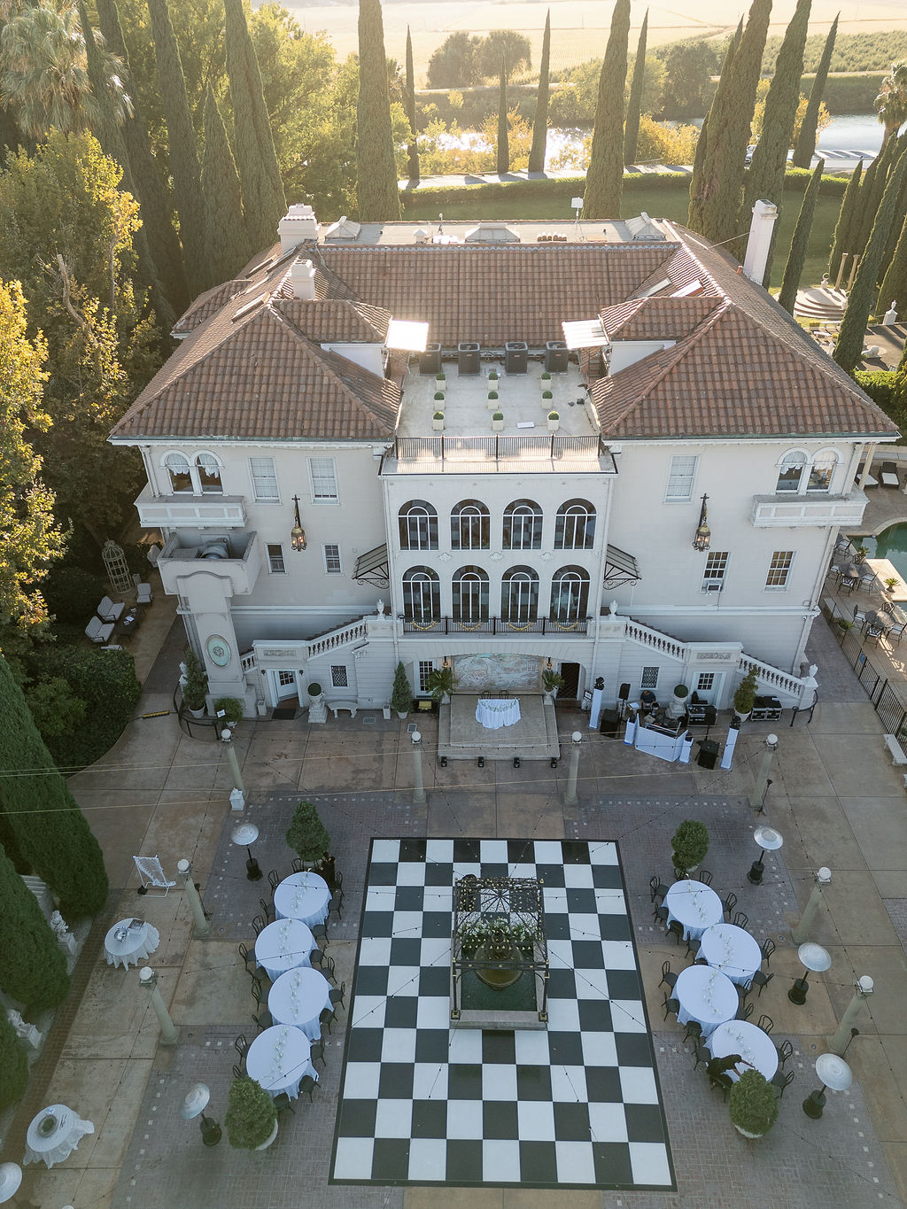 Aerial view of Grand Island Mansion with black and white courtyard dance floor and round guest tables.