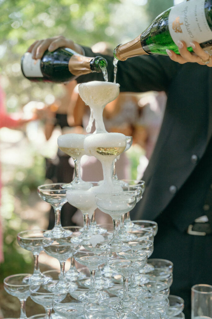 Champagne tower being poured during the cocktail hour at a Mendocino wedding.