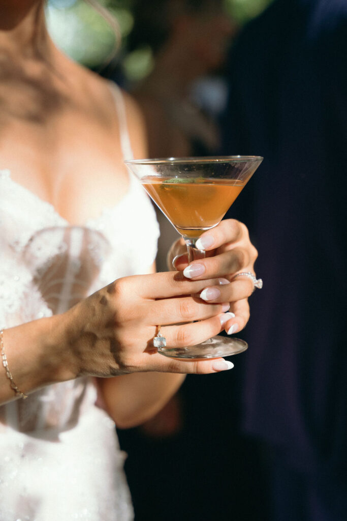 Close-up of a bride holding a martini glass during cocktail hour at a Mendocino wedding.