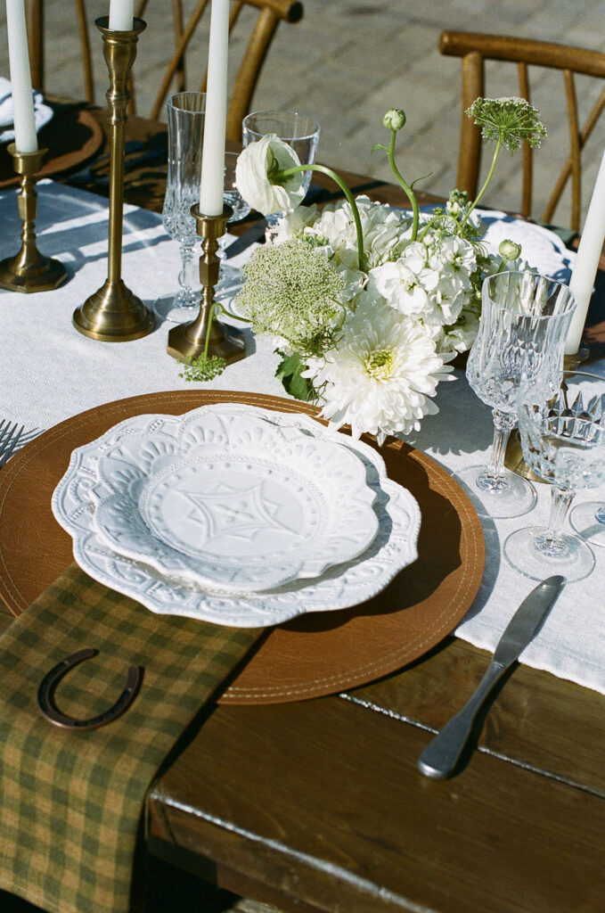 Elegant wedding table setting with white floral arrangements and brass candleholders at Monserate Winery