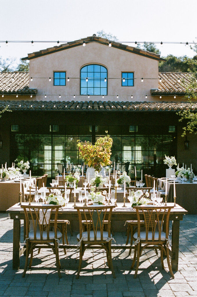 Outdoor wedding reception setup at Villa De Fiore, featuring rustic tables and Tuscan-inspired architecture