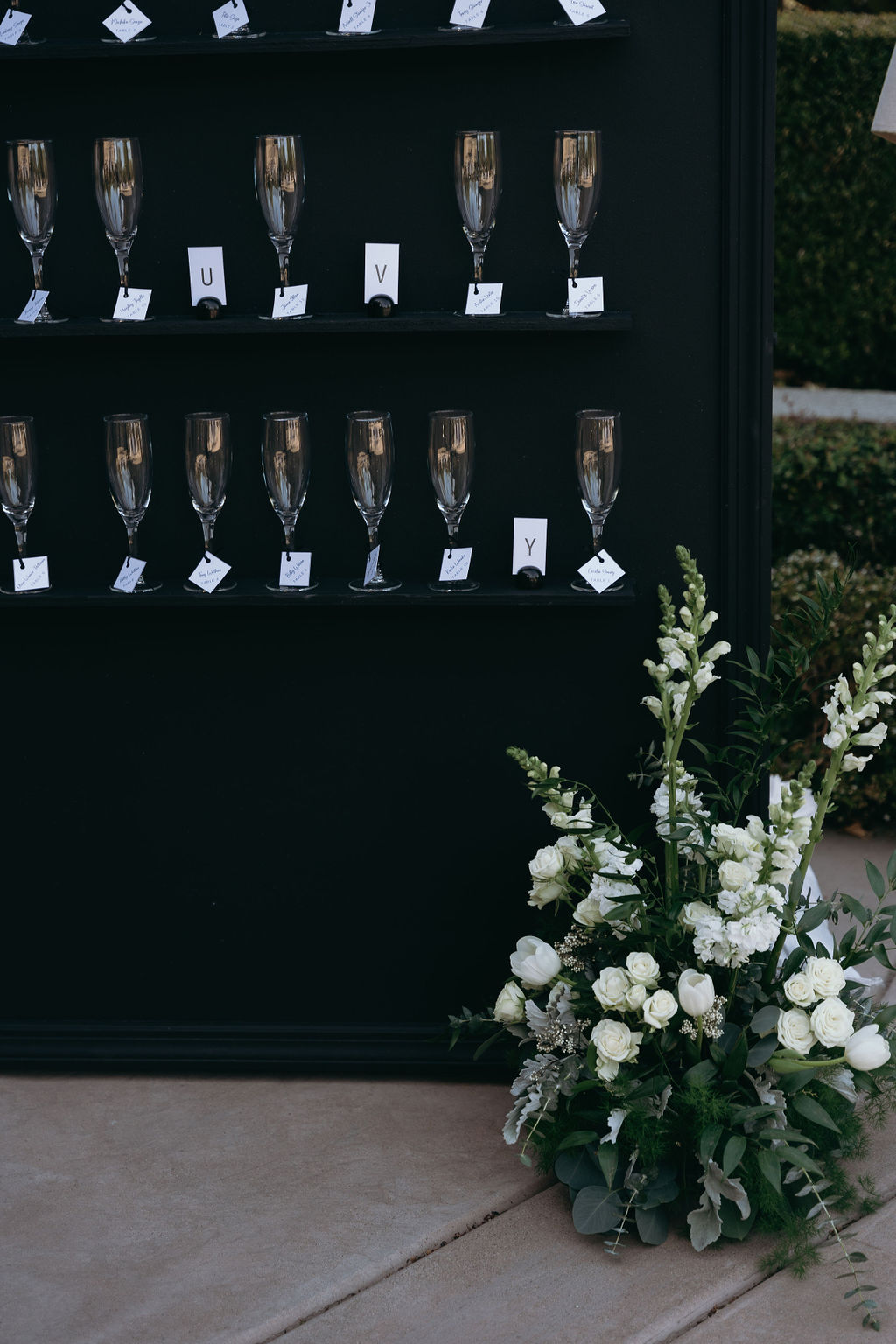 Wall of champagne glasses for guest seating assignments featuring the couple’s initials at Wolfe Heights.