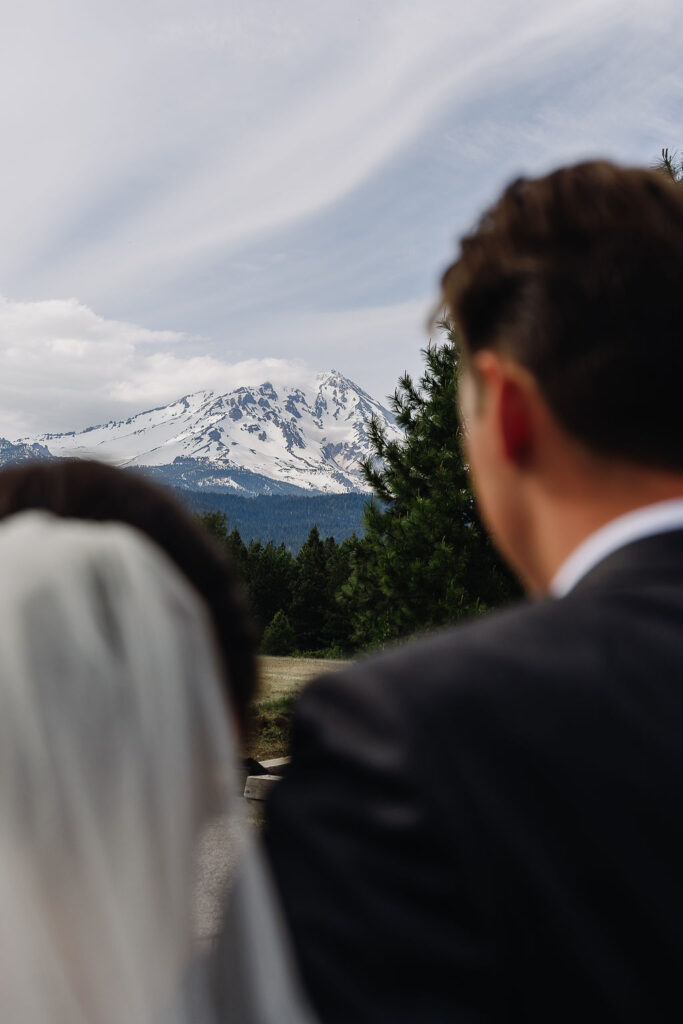 Bride and groom admire the breathtaking view of Mount Shasta at their McCloud wedding captured by a northern california wedding photographer