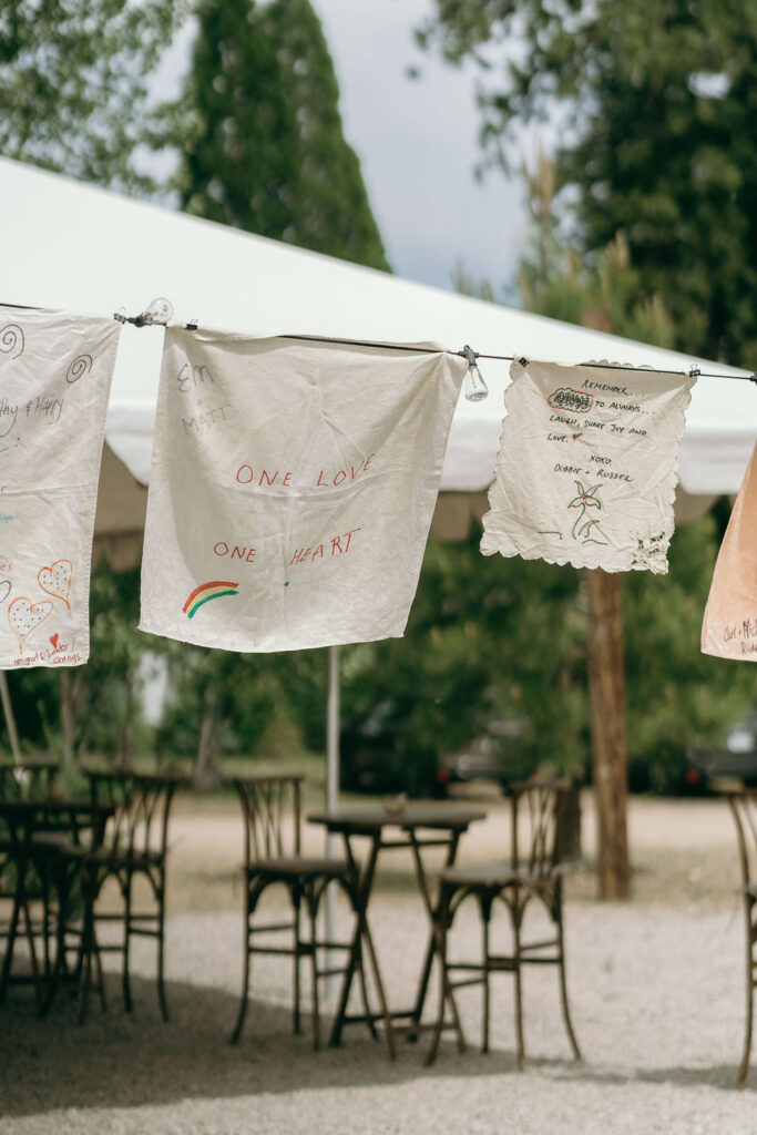 Handmade guest fabric banners with heartfelt messages displayed at an outdoor wedding captured by a Northern California Wedding Photographer