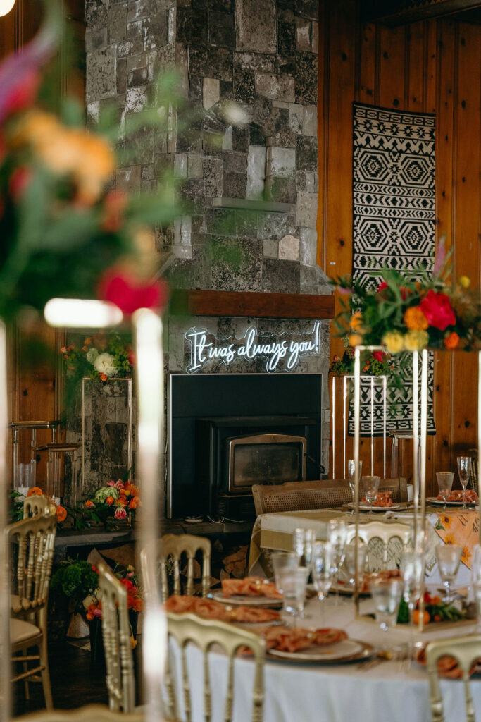 Wedding reception fireplace with "It was always you" neon sign and lush floral decor captured by a Northern California Wedding Photographer