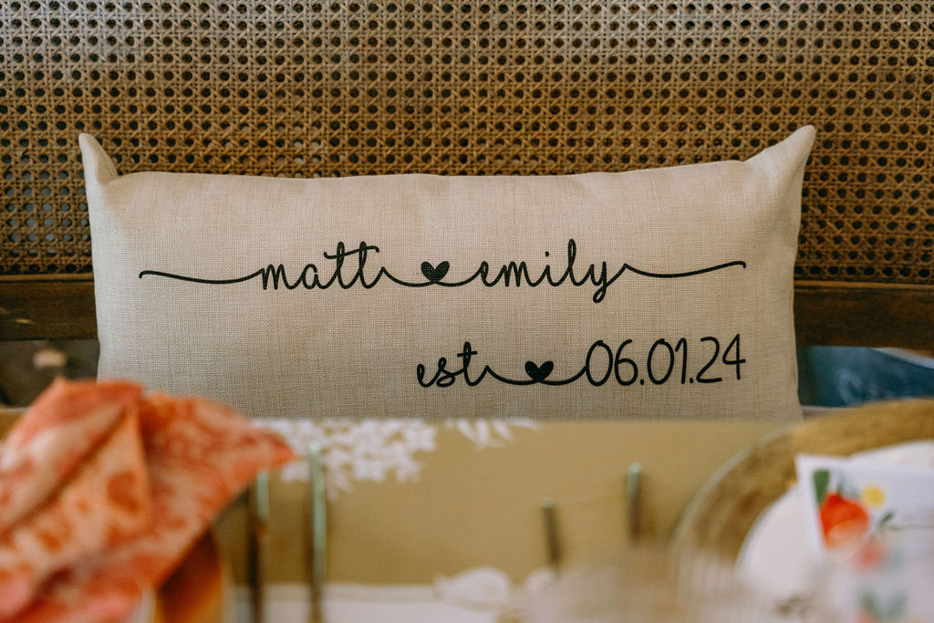 Personalized wedding pillow with "Matt & Emily est. 06.01.24" embroidered in black script.