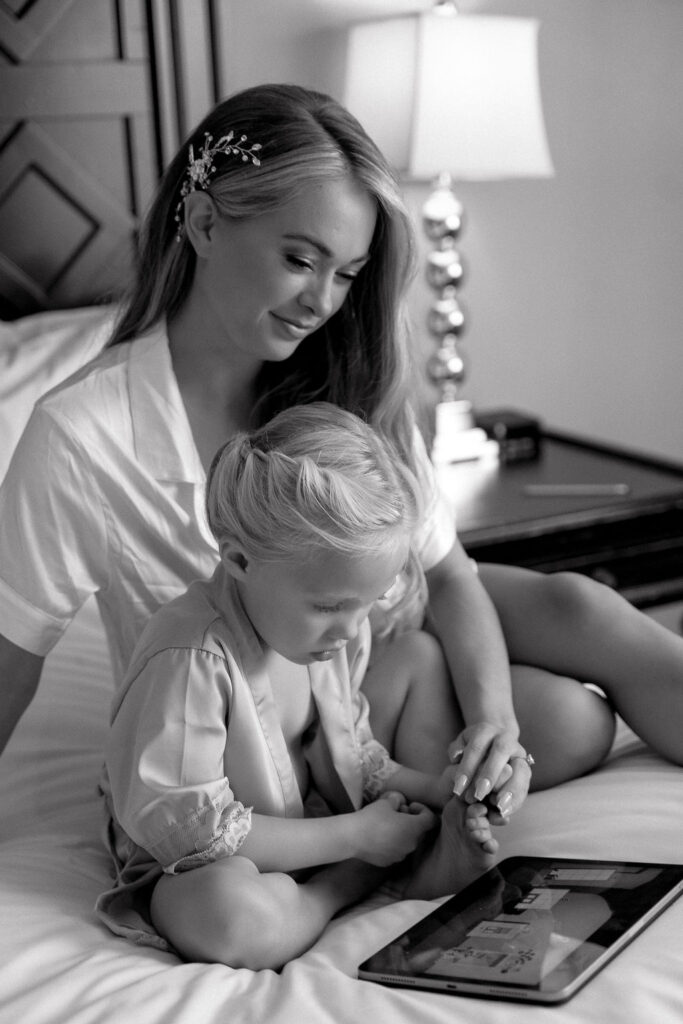  Bride sharing a tender moment with a flower girl before getting dressed, highlighting candid getting ready moments