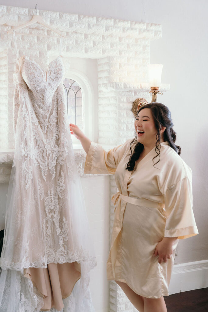 Bride in a ruffled robe playfully posing before getting ready for her wedding