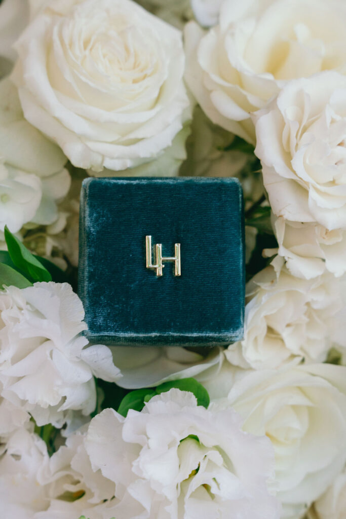 Velvet ring box with custom gold initials surrounded by white roses