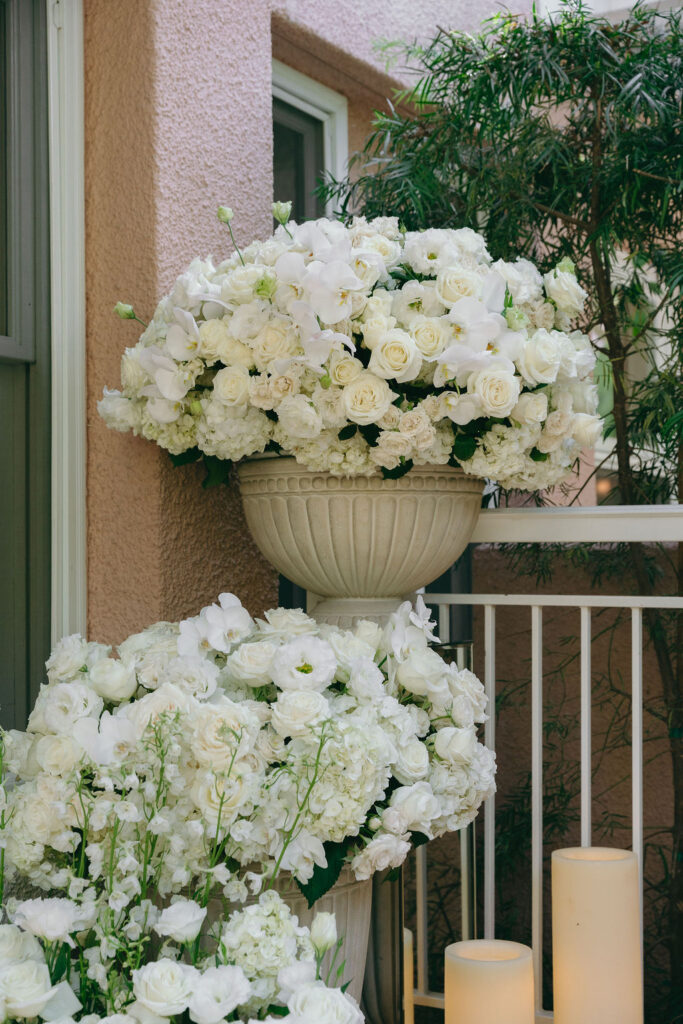 Elegant floral arrangement of white roses and orchids in a los angeles proposal setting.