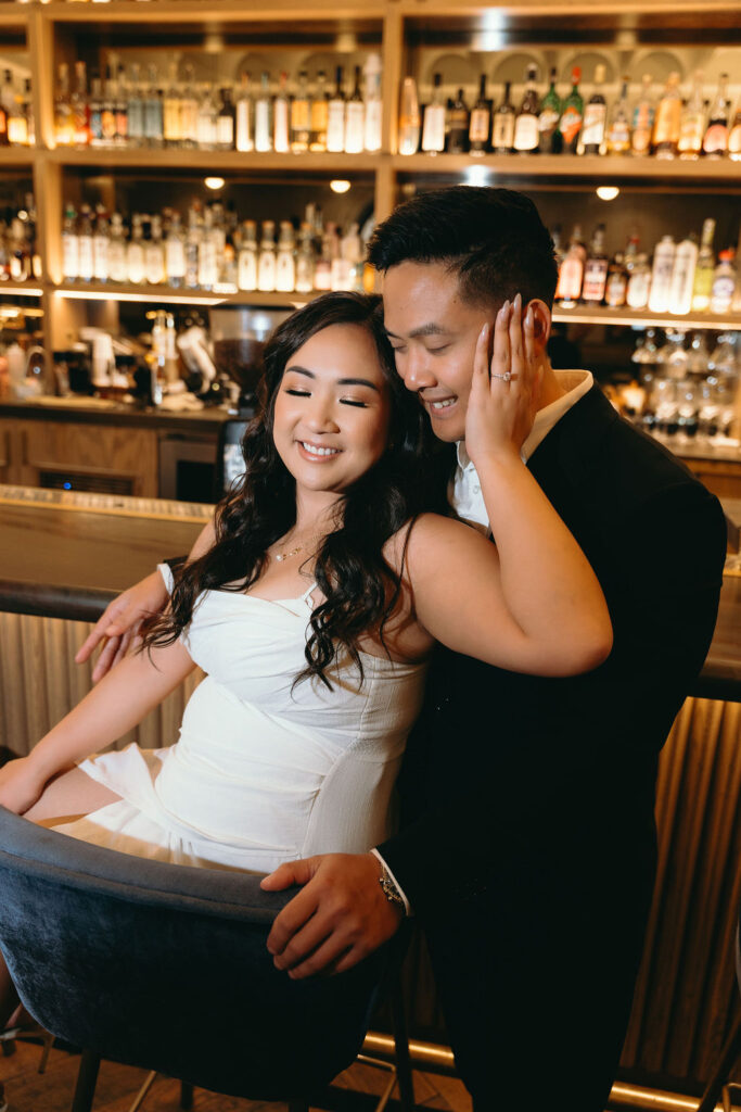 A candid moment of ViLan and Jason laughing at the bar, showcasing their engagement session in San Diego.