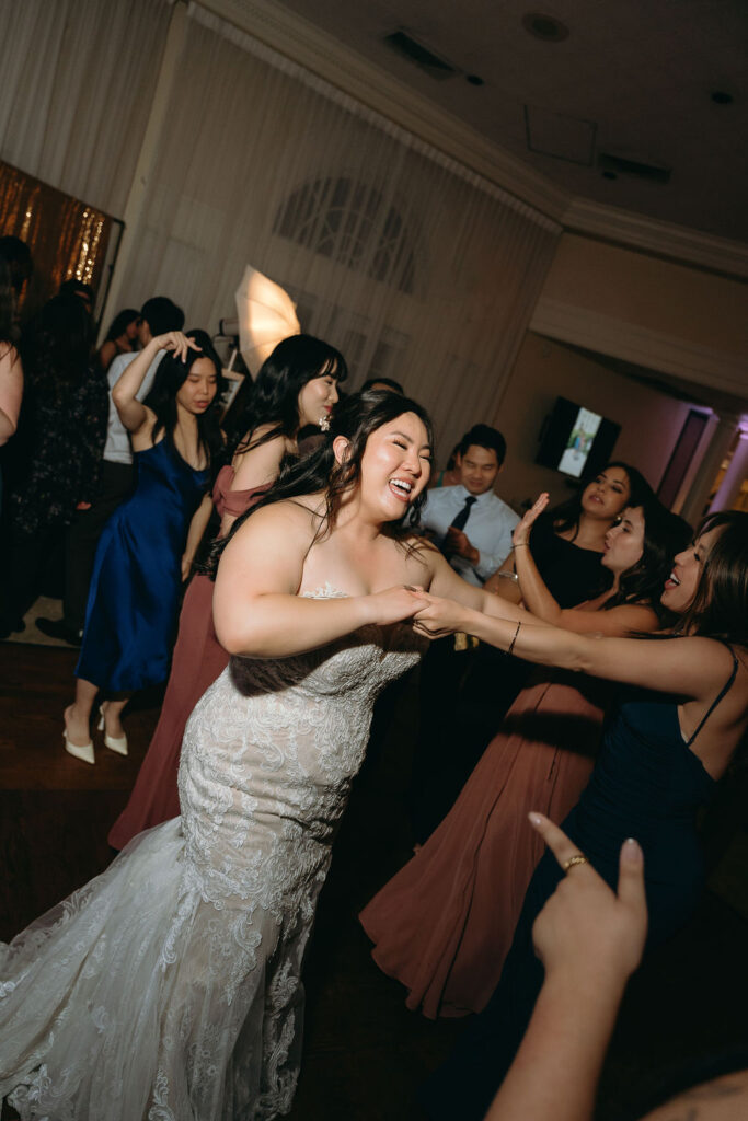 Bride surrounded by friends celebrating on the dance floor at Vizcaya Sacramento