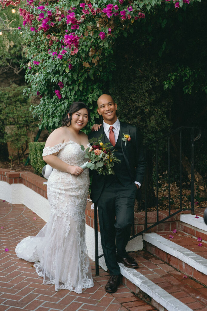 Bride and groom pose in Vizcaya Sacramento’s garden, framed by lush greenery and brick pathways