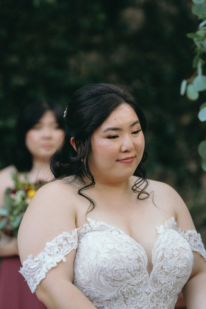 Bride laughs while reading vows at Vizcaya Sacramento, standing in front of a lush green backdrop.