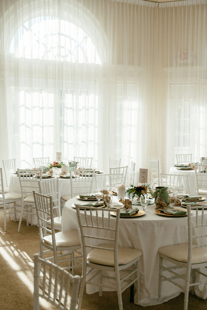 Sunlit reception hall at Vizcaya Sacramento with white drapery, elegant tablescapes, and gold-accented decor