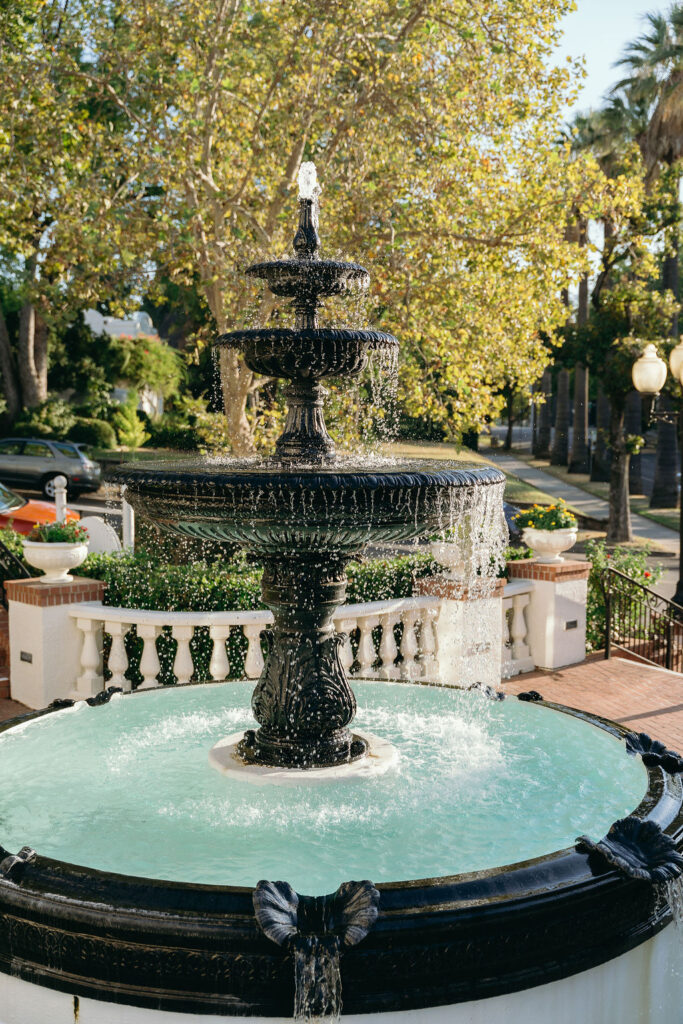 Ornate black fountain at Vizcaya Sacramento with cascading water, surrounded by historic architecture and trees