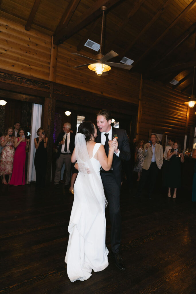 Bride twirls on the dance floor, celebrating with guests at the reception.