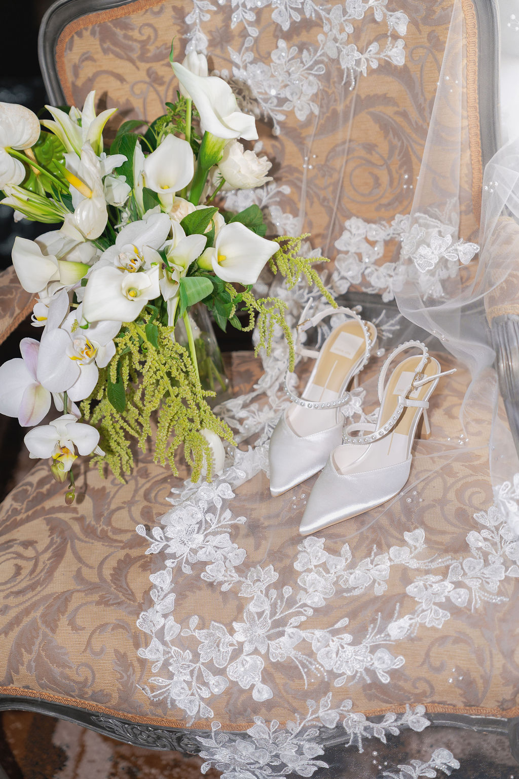 Wedding flat lay at Grand Island Mansion with invitation, rings, shoes, and silver tray.