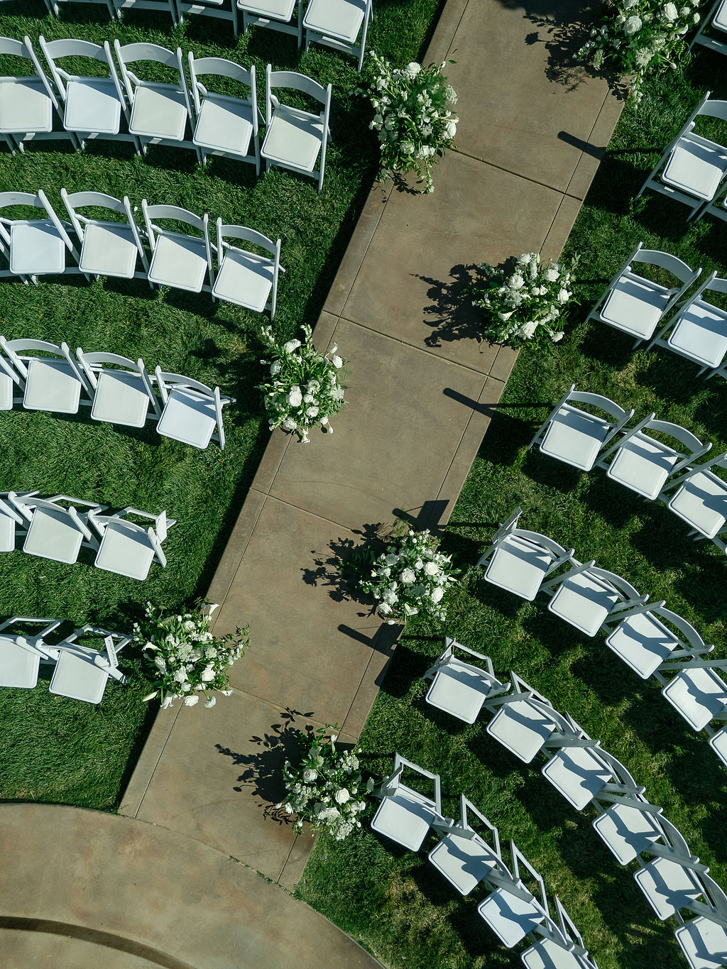 . Ceremony seating at Grand Island Mansion lined with white chairs and calla lily floral arrangements.