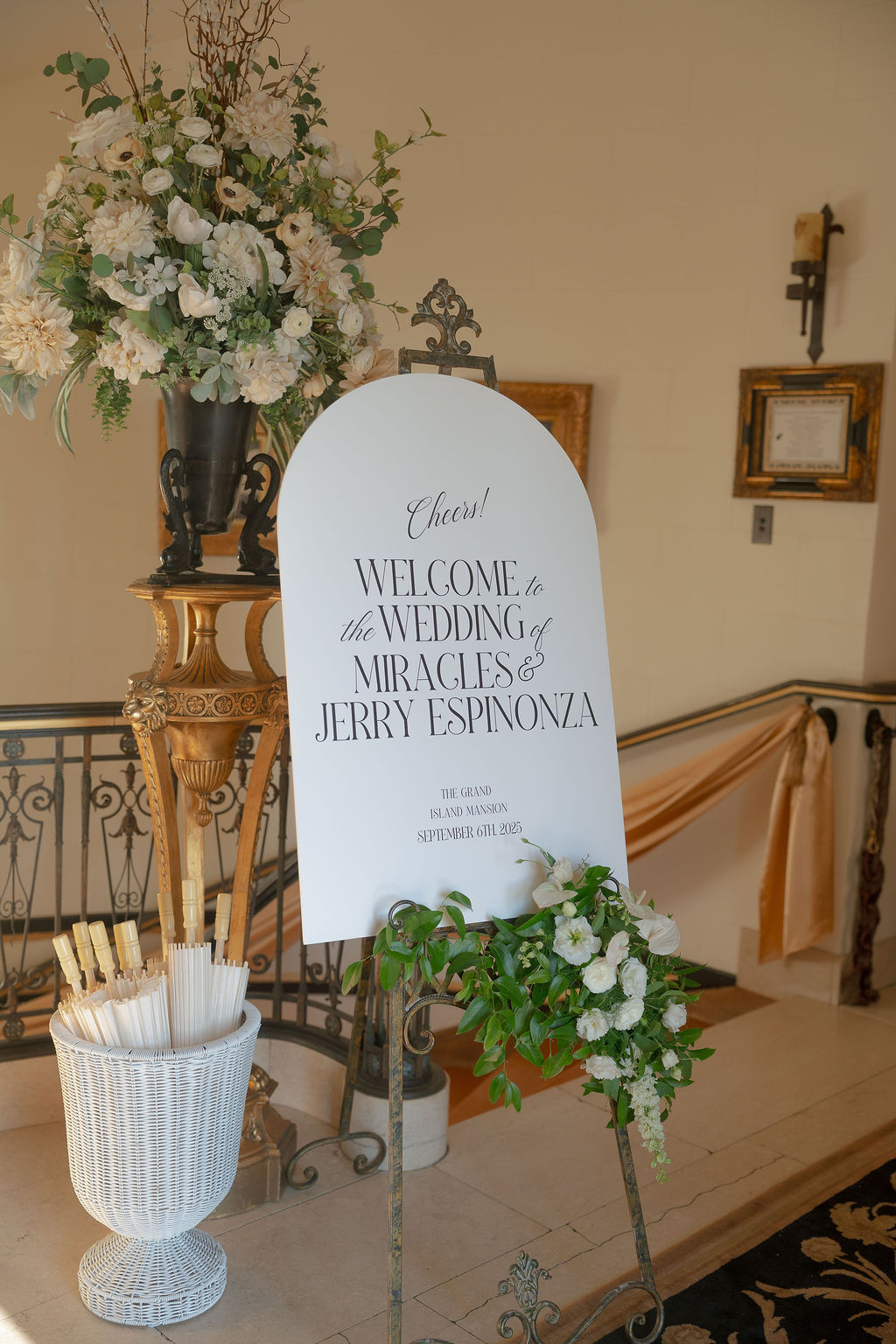 White welcome sign with florals inside Grand Island Mansion entryway.