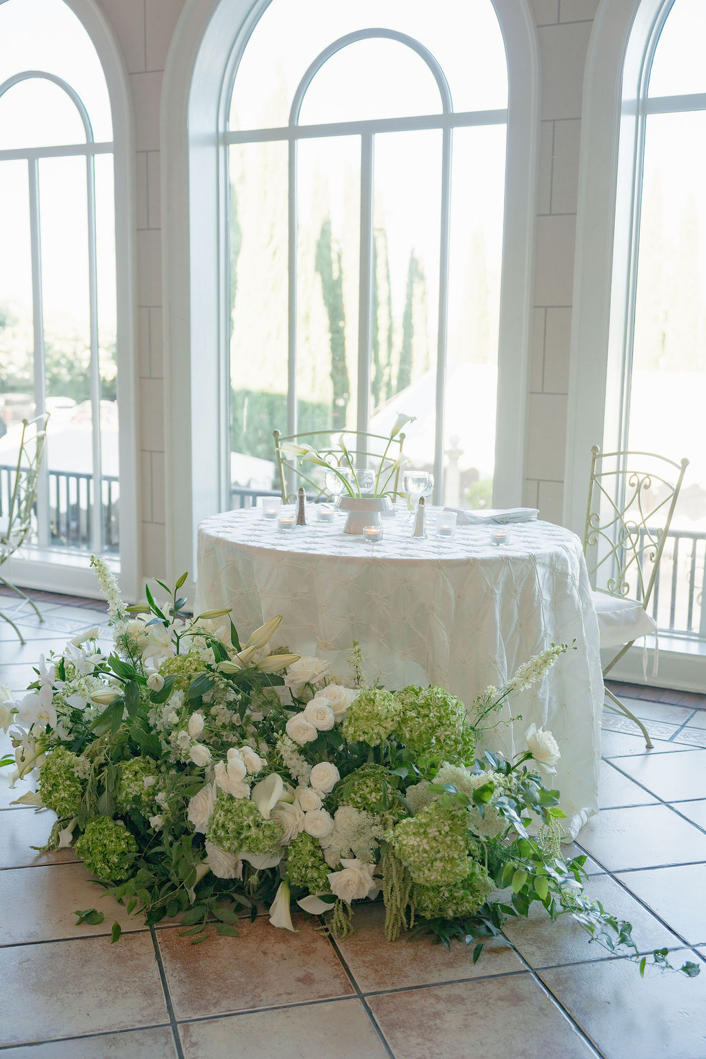 Sweetheart table with lush white florals inside Grand Island Mansion.