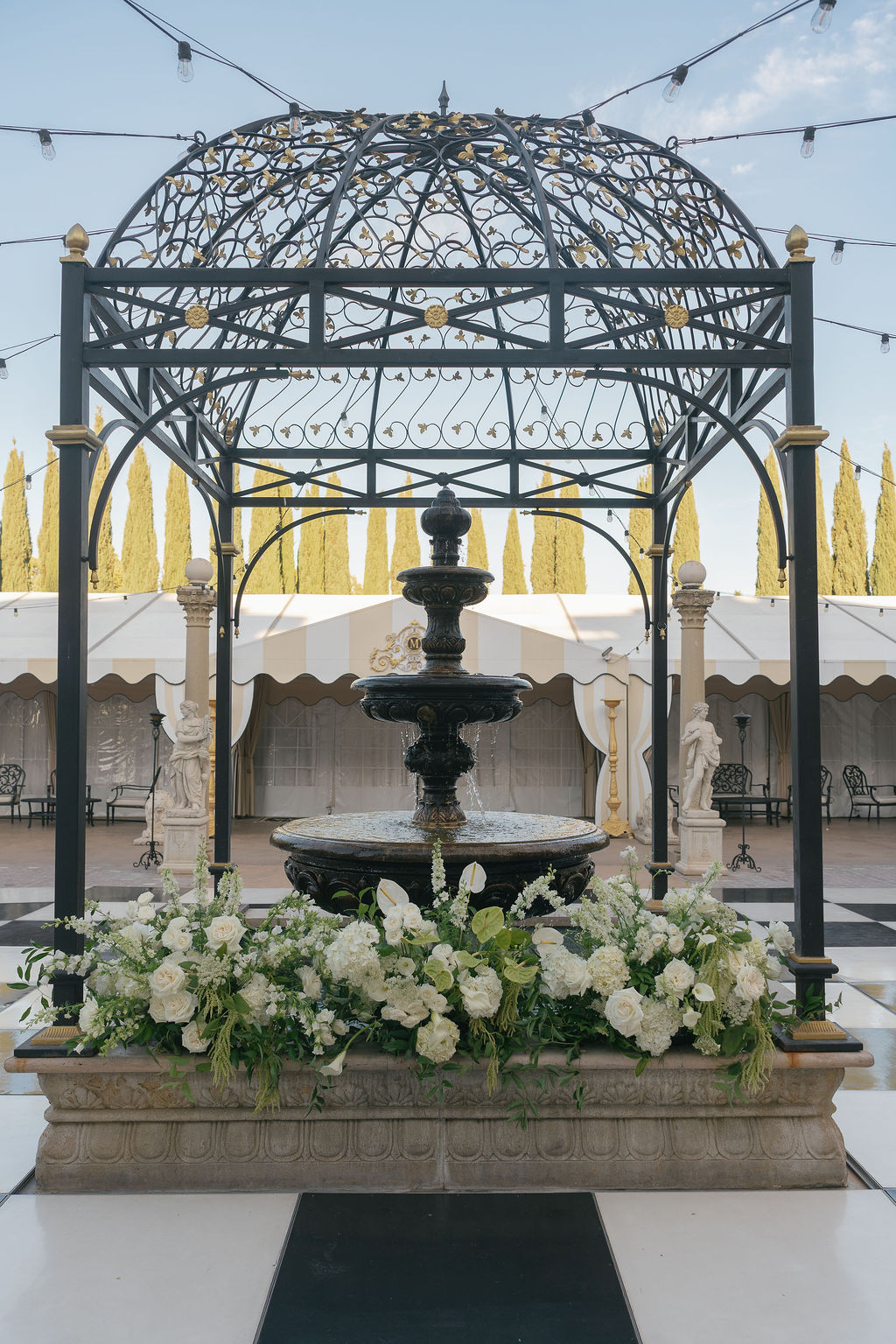 Courtyard fountain with white floral arrangements at Grand Island Mansion.