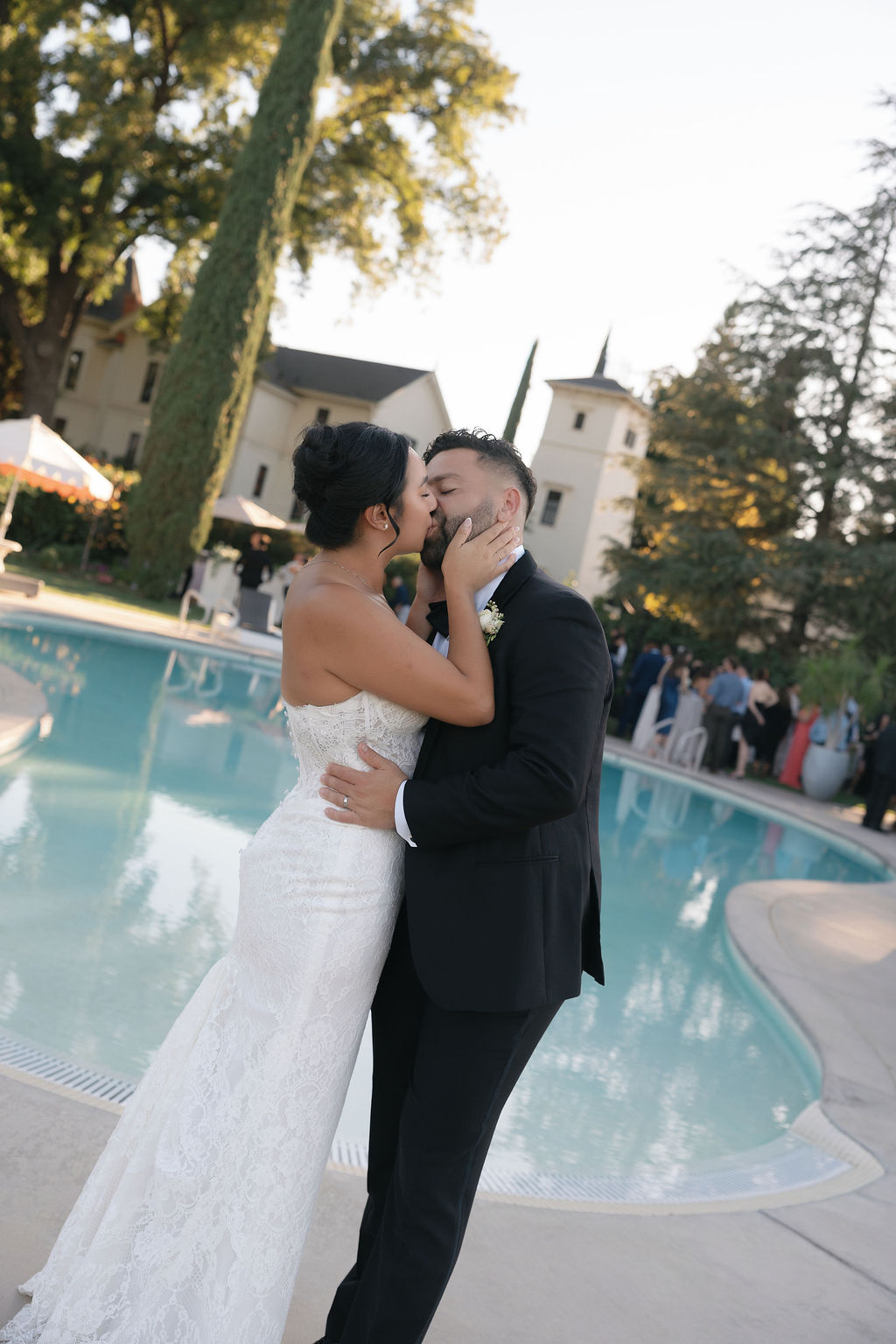 Bride and groom share a kiss by the pool at their Park Winters wedding.