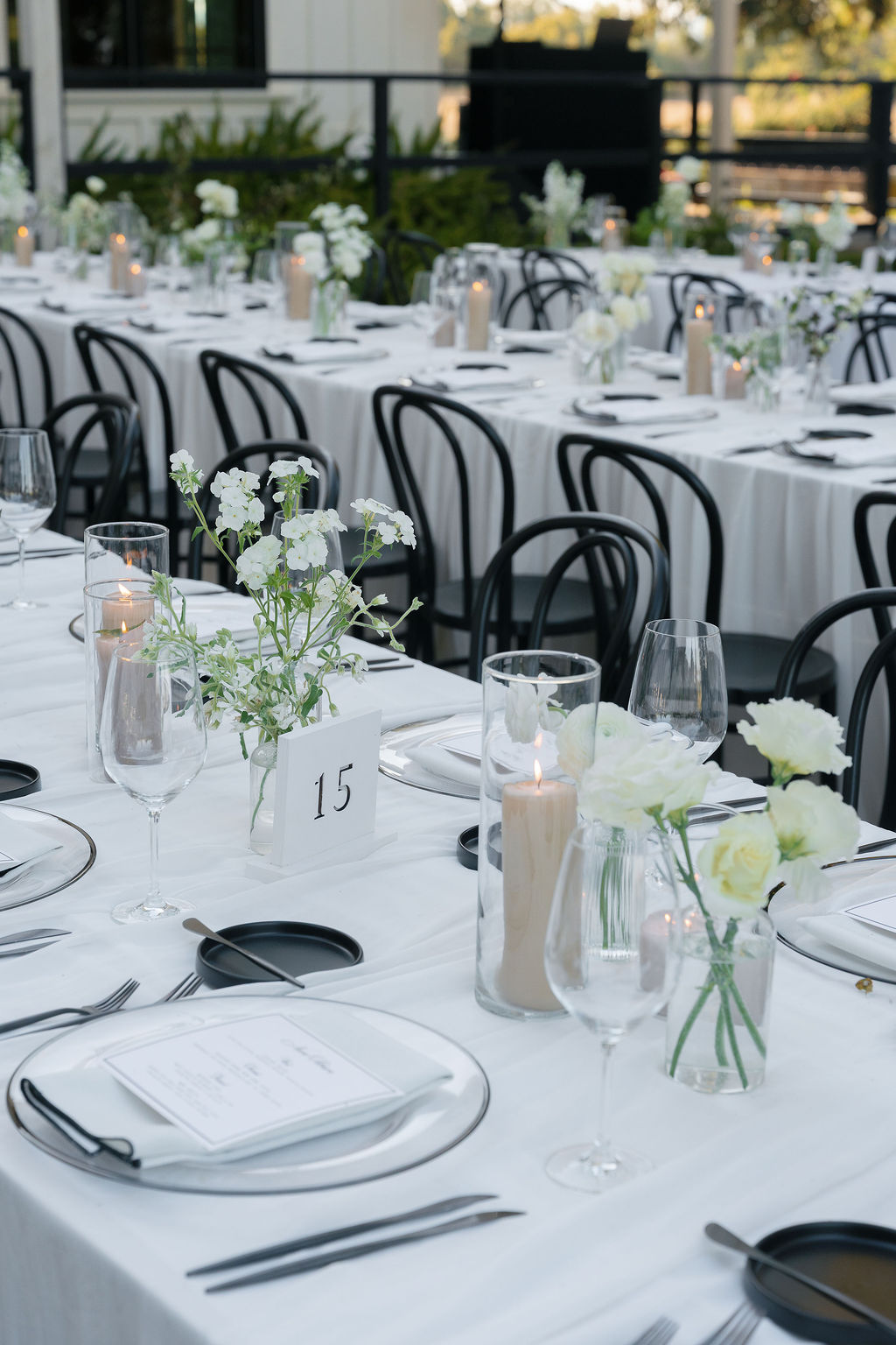 Elegant outdoor reception table setup at Park Winters Wedding with modern black chairs and white florals.