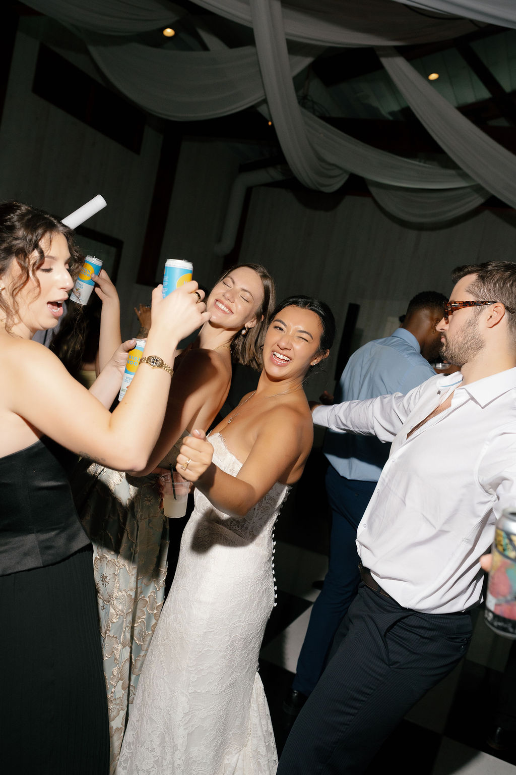 Bride dances with friends holding drinks during Park Winters Wedding reception