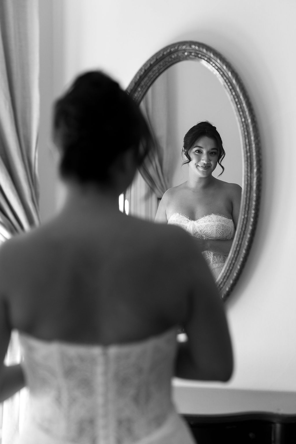 Bride smiling at her reflection in mirror before Park Winters wedding ceremony.